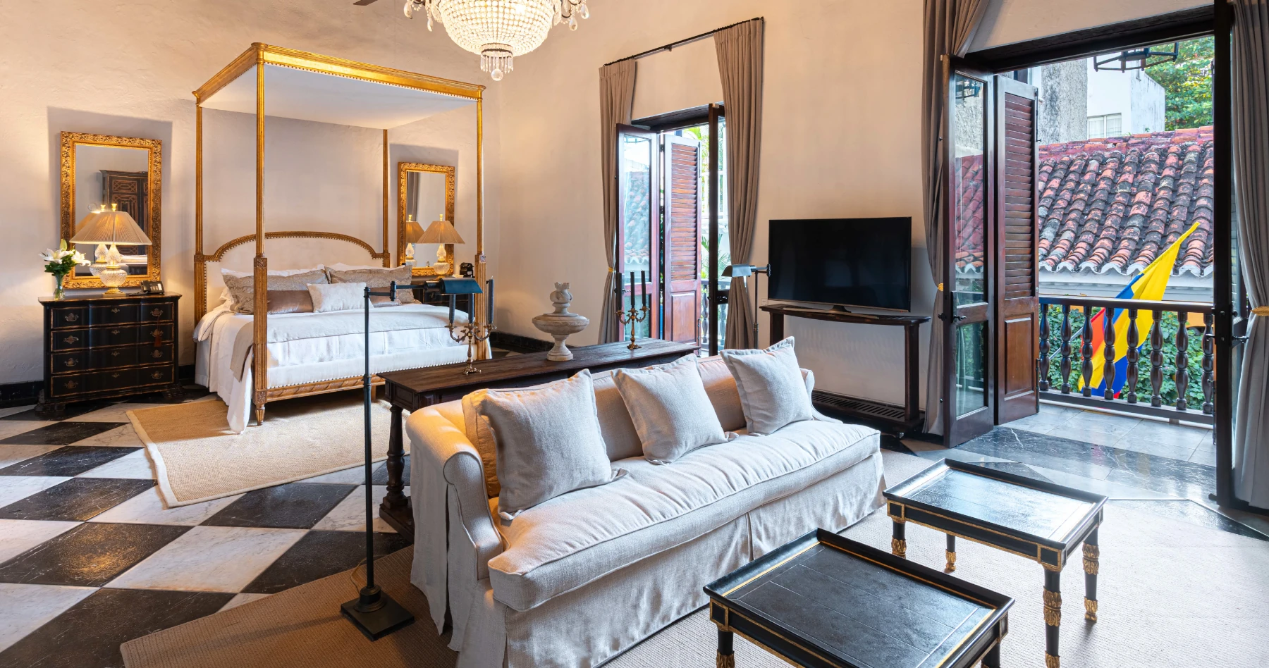 Dormitorio principal de lujo con cama King size, cabecero tapizado en azul y techos altos de madera rústica con ventilador de diseño