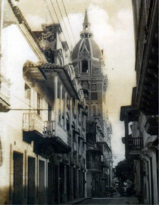 Fotografía antigua en blanco y negro de una calle de Cartagena con la cúpula de la Catedral al fondo