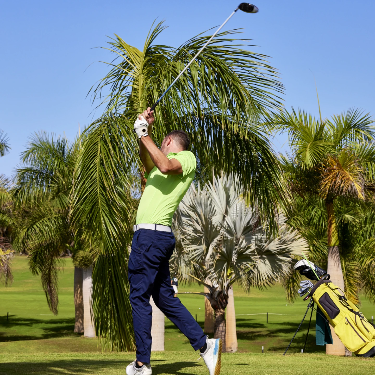 Jugador de golf realizando un swing en campo de lujo frente al mar