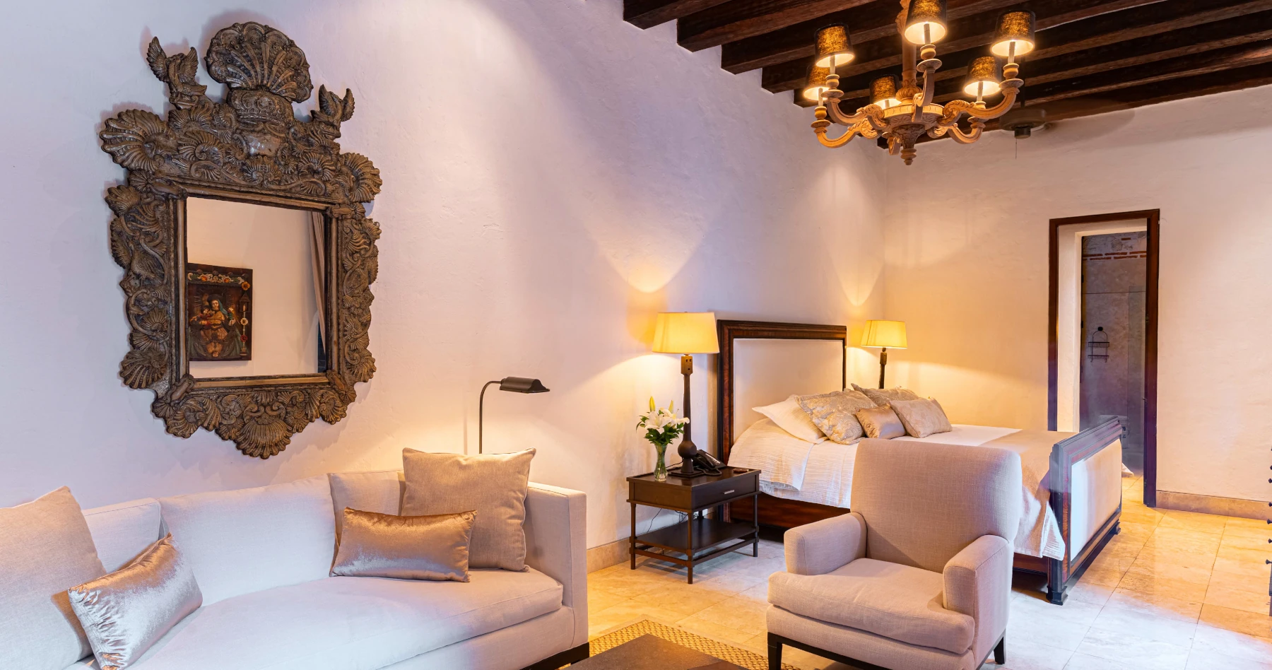 Suite de lujo con dos camas dobles, sábanas de alta densidad y una arquitectura impresionante con techos de madera oscura y vigas expuestas